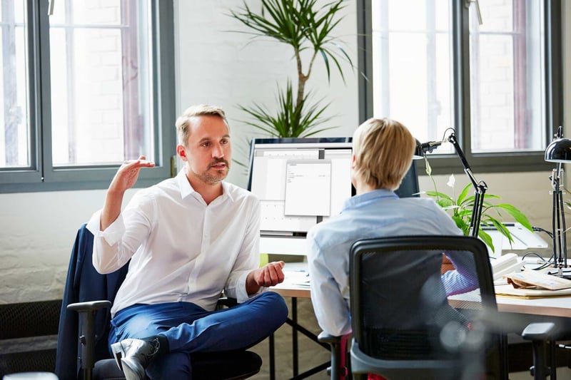 Businessman-Discussing-With-Colleague-In-Office-how-to-give-feedback-to-your-boss