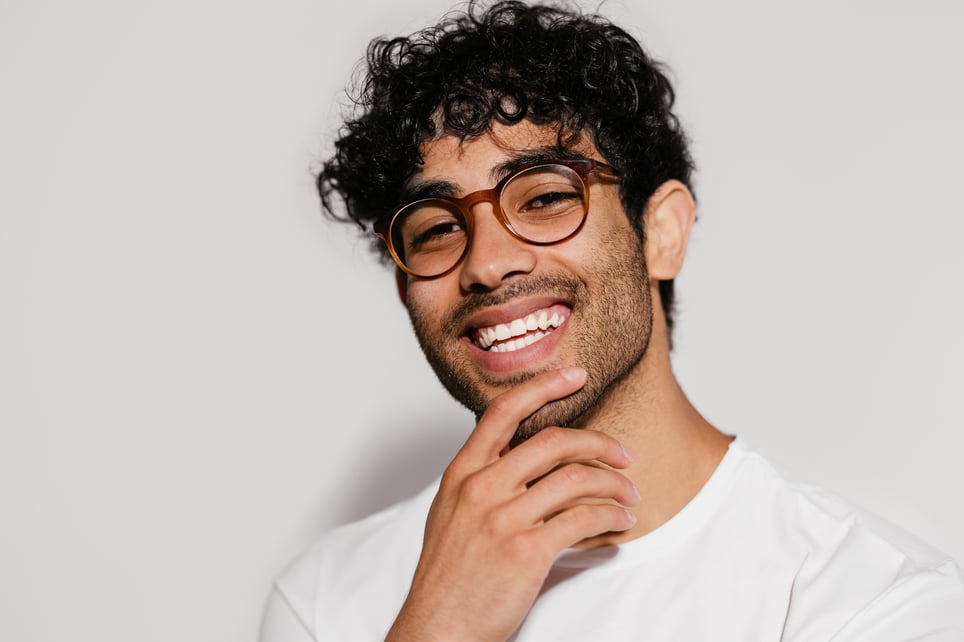 Cheerful-Hispanic-Guy-In-Glasses-Thinking-positive-thinking-benefits