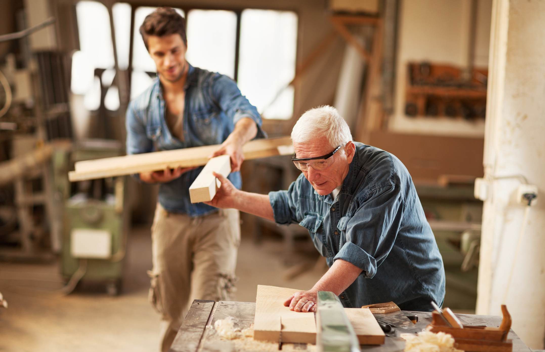 Elderly-worker-getting-help-from-younger-employee-at-fabric-why-is-there-a-labor-shortage