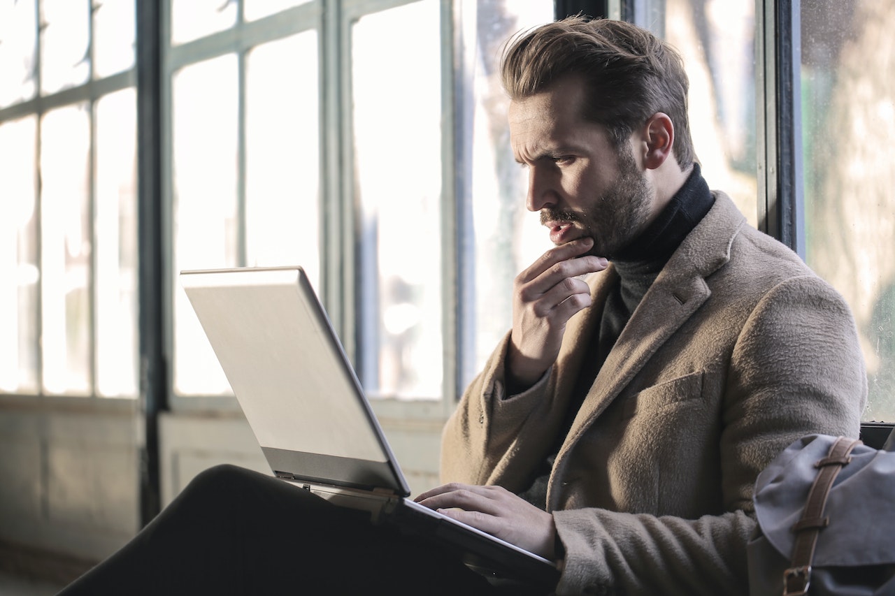 Focused-man-thinking-and-using-laptop-personal-branding