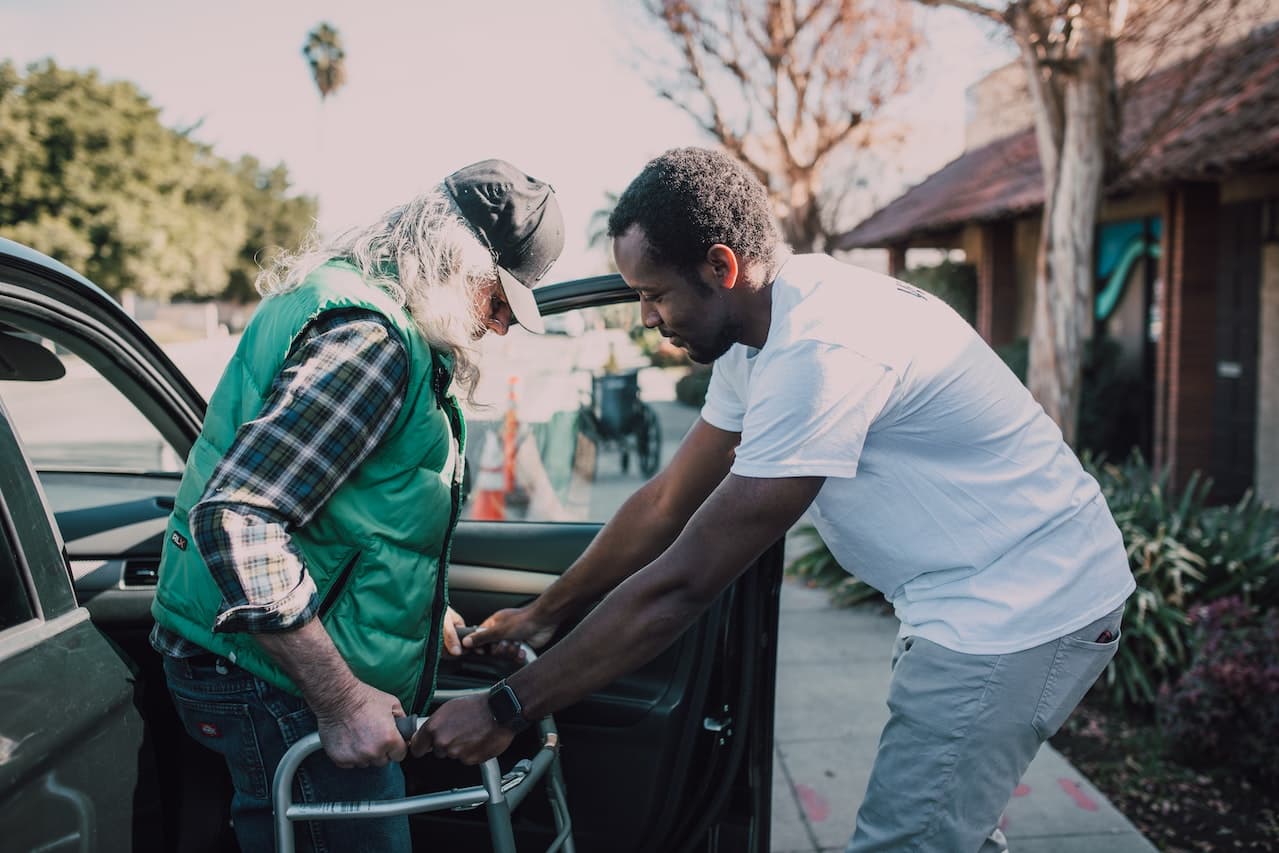 Man-Assisting-elder-Person-with-Walker-life-goals