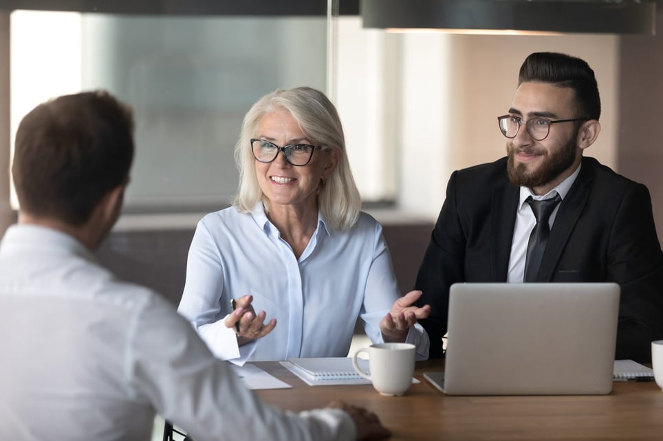 Man-and-woman-smiling-while-interviewing-man-what-motivates-you