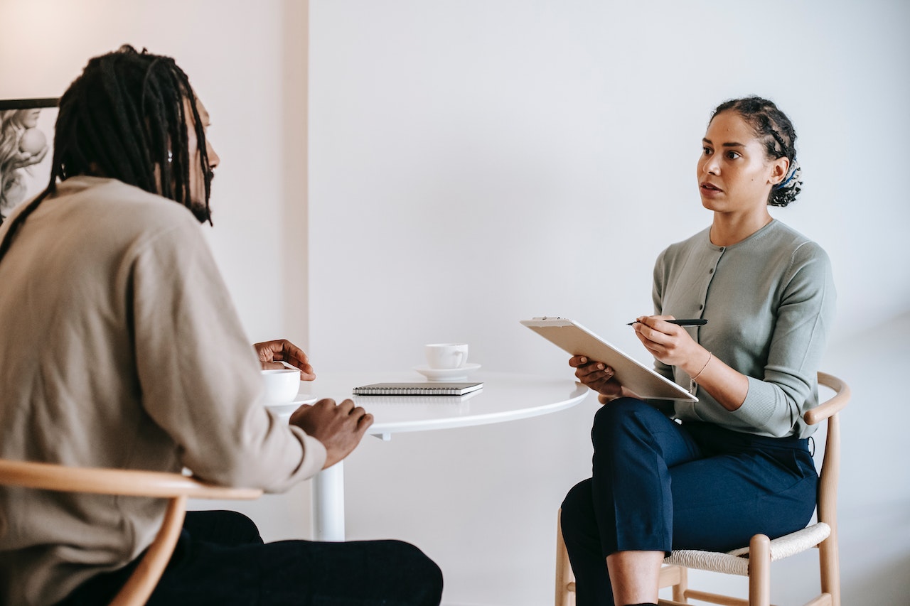 Man-at-therapy-session-with-woman-therapist-sibling-comparison