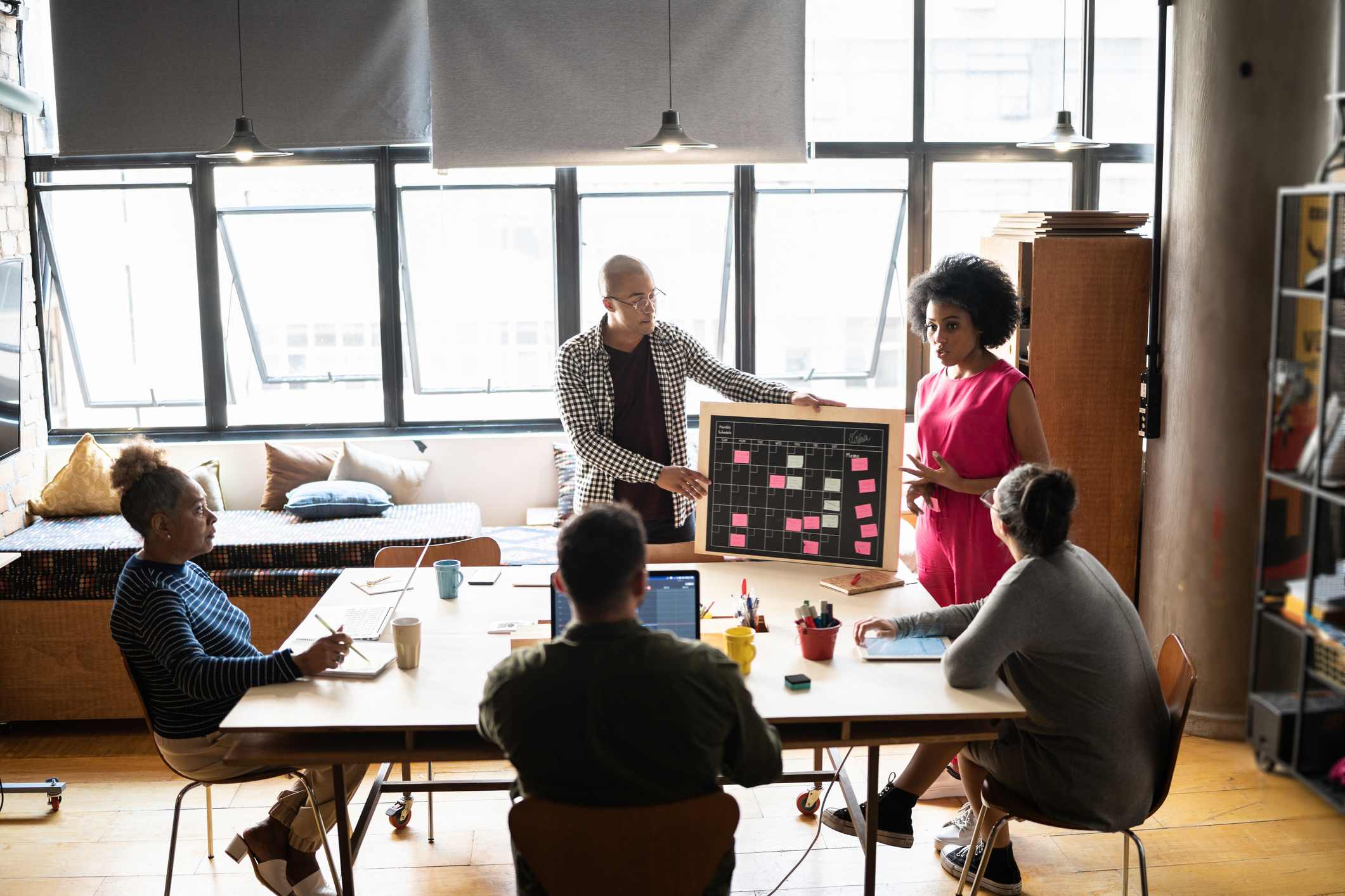 Marketing-managers-showing-content-calendar-to-team-at-meeting-marketing-degree-jobs