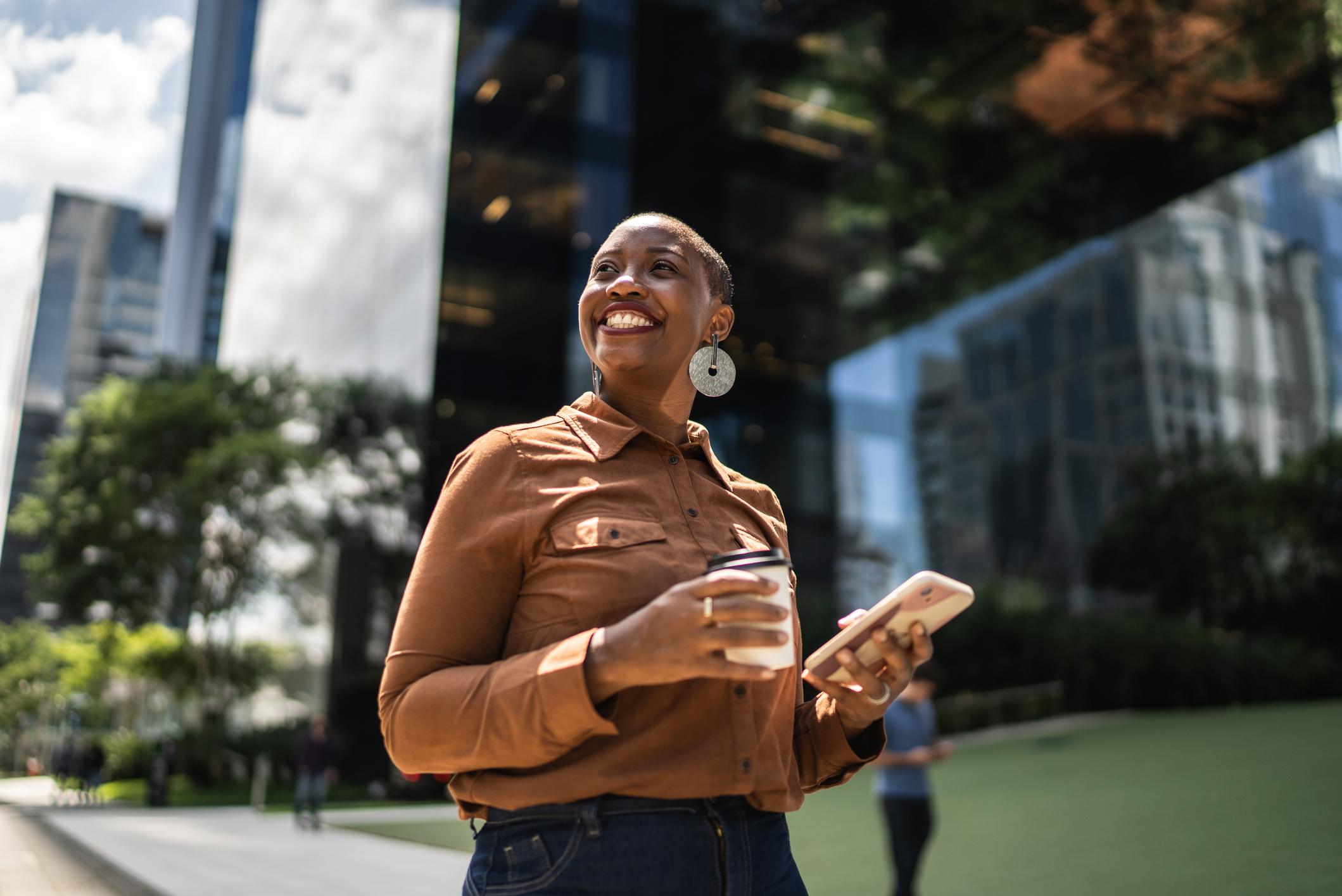 Motivated-woman-smiling-in-the-street-with-a-coffee-i-feel-like-i-dont-belonggydF4y2Ba