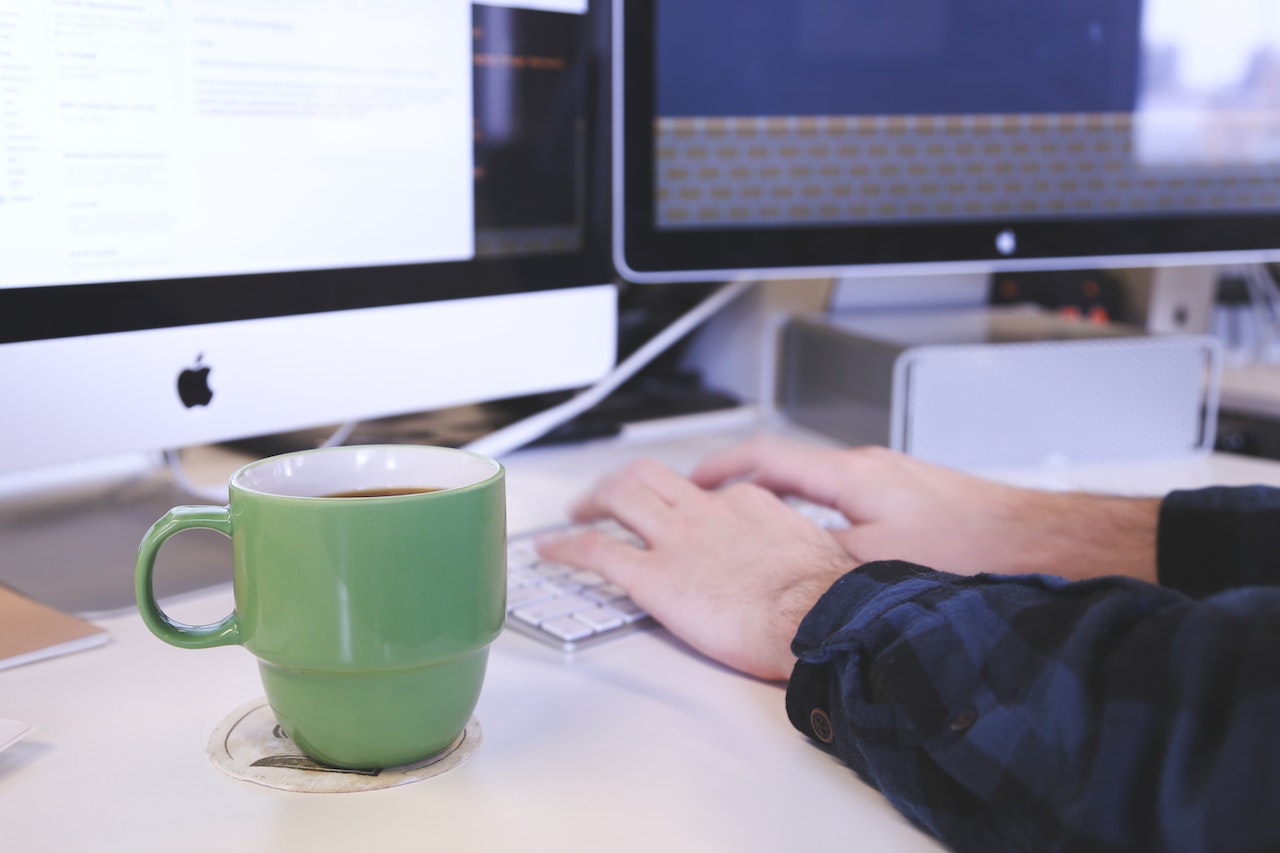 Person-Typing-on-computer-with-mug-next-to-them-thank-you-letter-after-interview
