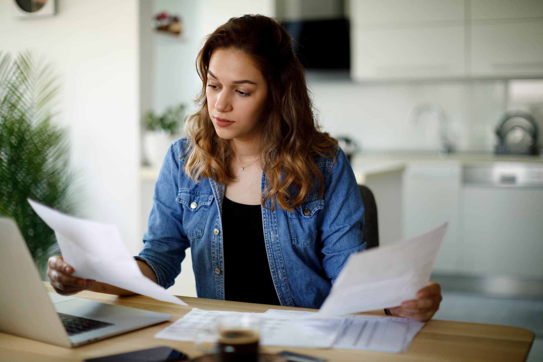 Serious-young-woman-working-at-home-choosing-between-two-jobs
