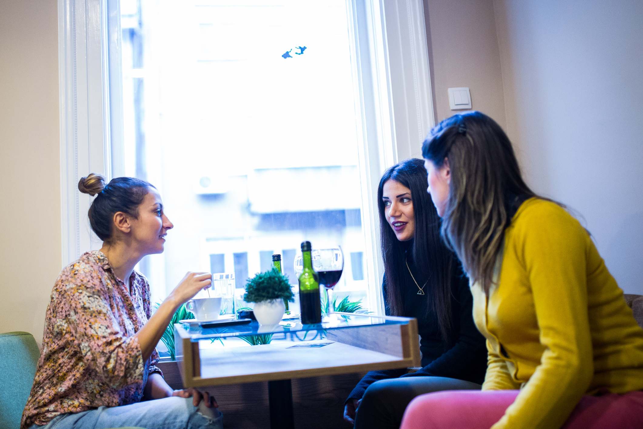 Three-young-women-talking-happy-life-vs-meaningful-life