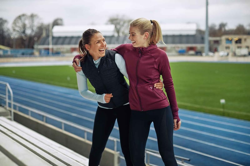Two-Women-Laughing-On-Running-Track-Bleachers-how-to-be-disciplined