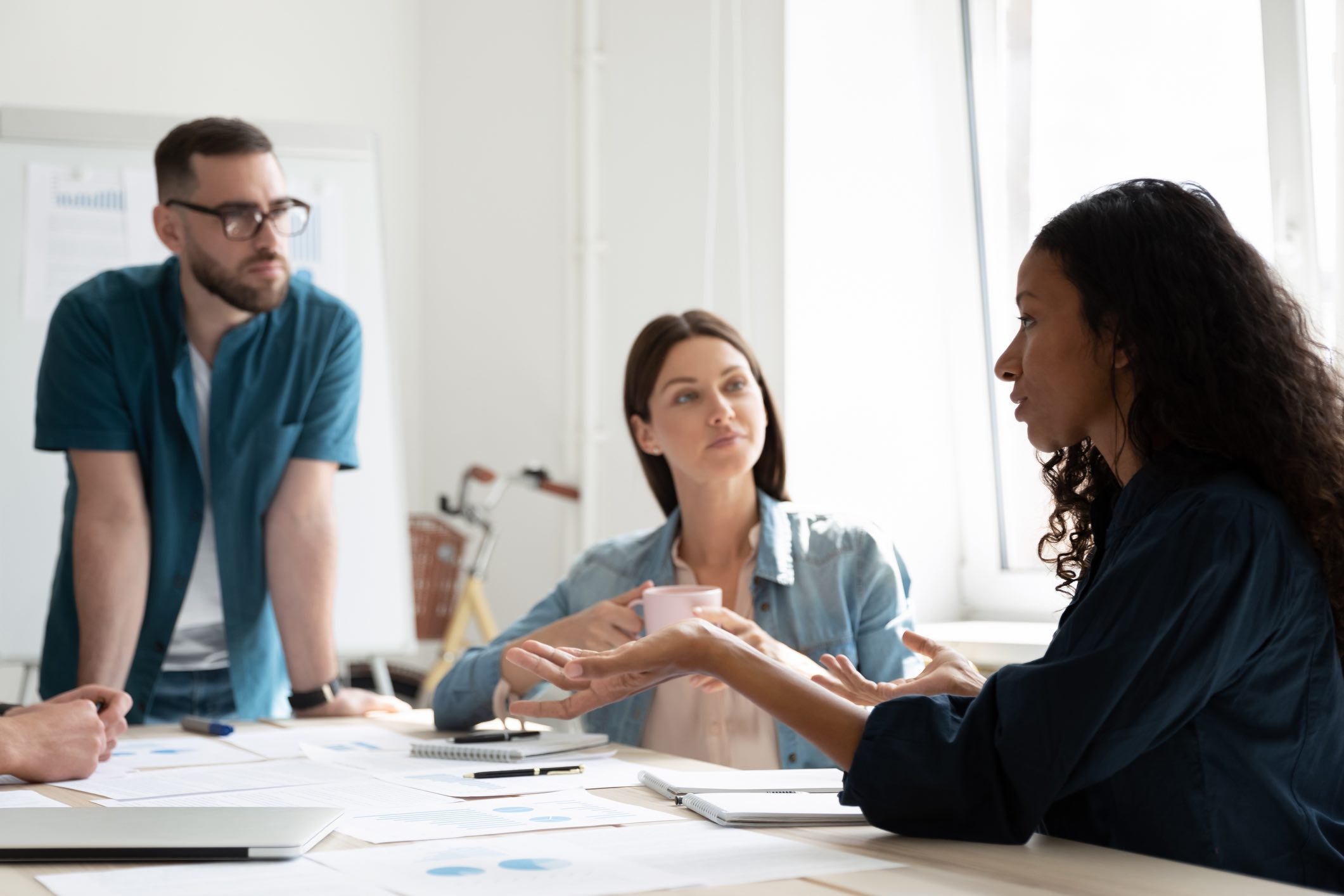 Two-coworkers-listening-to-a-woman-leading-a-brainstorming-session-cognitive-empathy