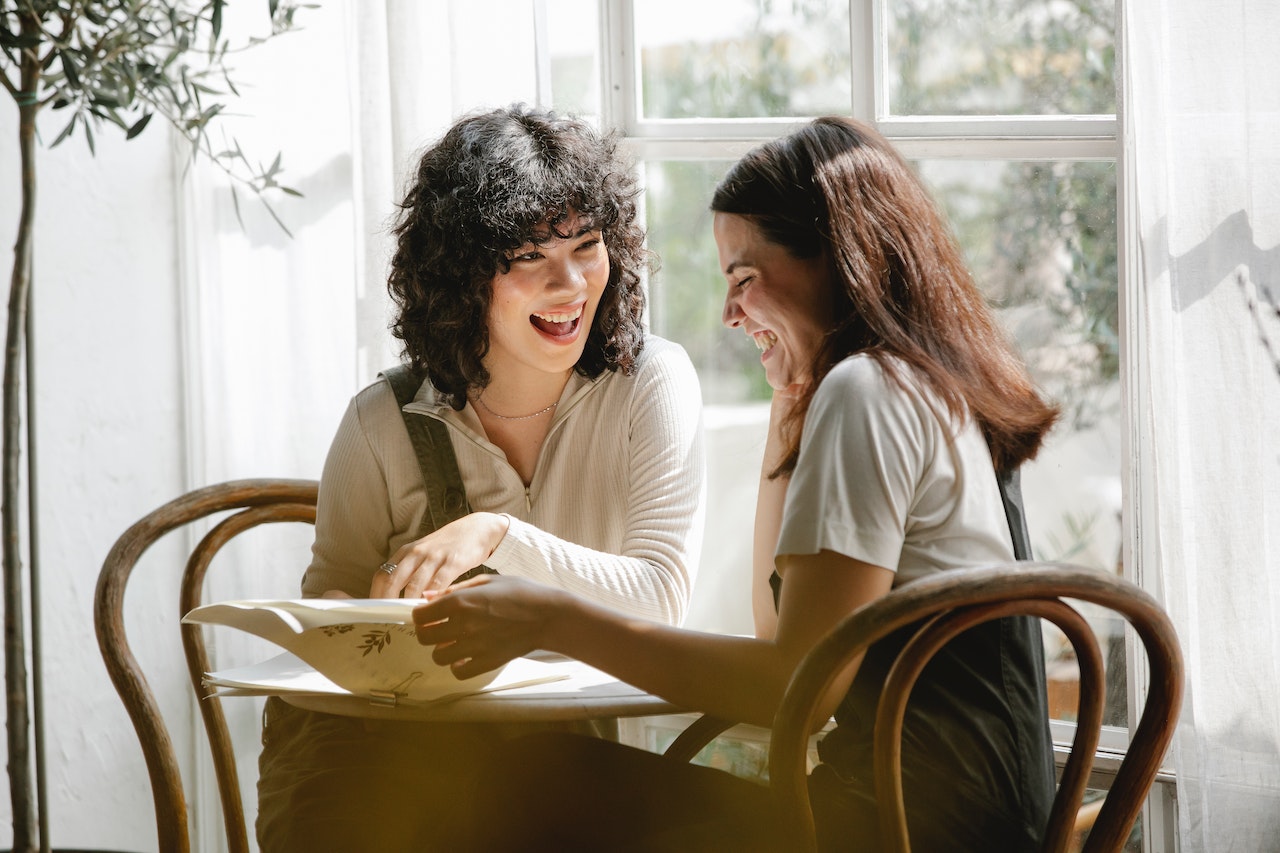 Two-women-laughing-together-at-table-personal-brand-statement