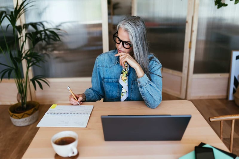 Woman-Making-Notes-On-Desk-how-to-forget-the-past
