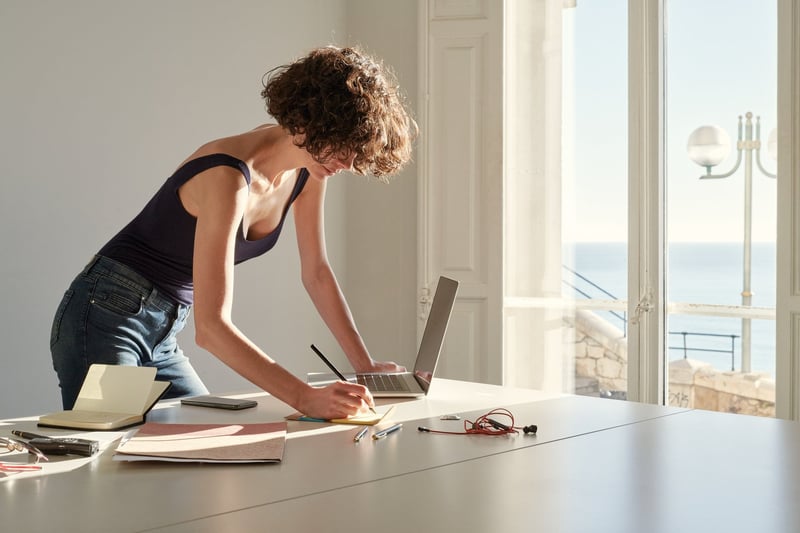 Woman-Writing-Notes-In-Notepad