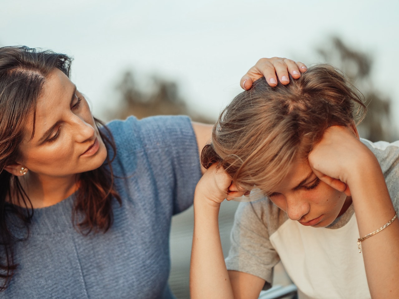 Woman-comforting-her-teenage-son-sibling-comparison