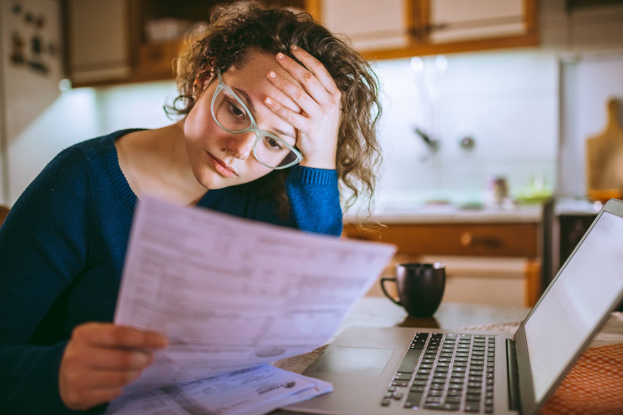 Woman-going-through-bills-how-to-start-a-manifestation-journal