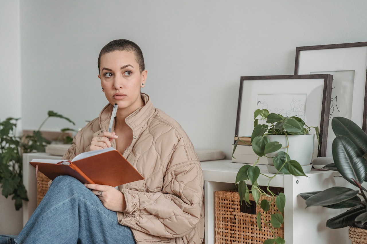 Woman-journaling-thoughtfully-in-her-room-sibling-comparison