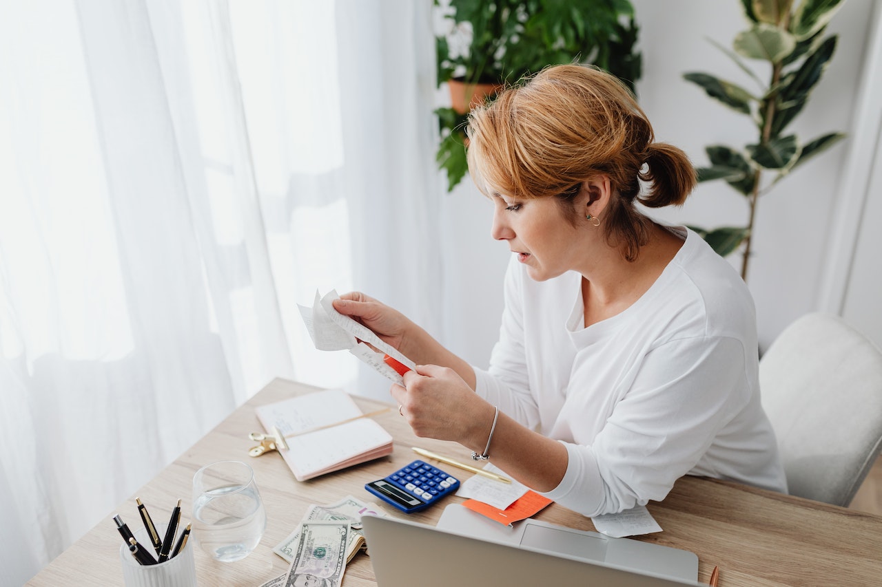 Woman-looking-at-bills-and-counting-money-things-to-manifest-ideas