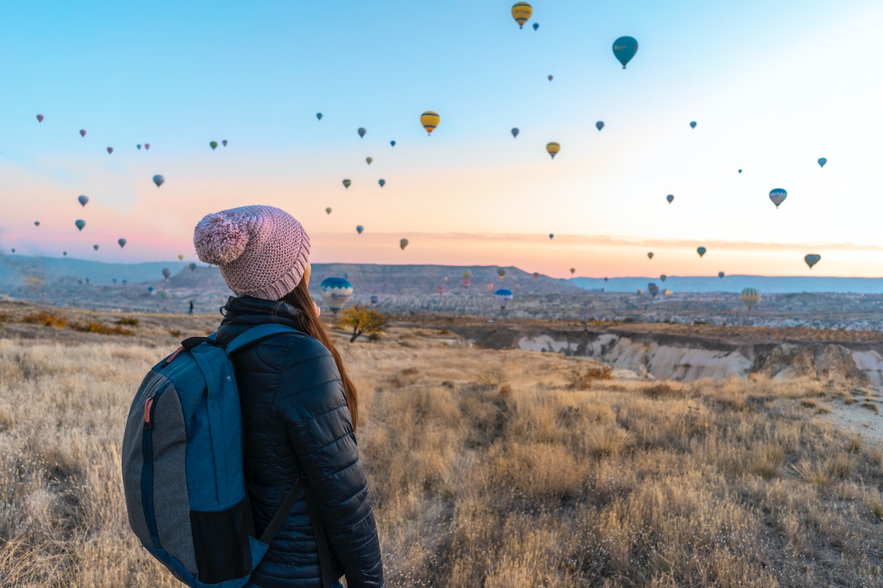 Woman-looking-at-hot-air-balloons-on-travel-location-why-take-a-gap-year