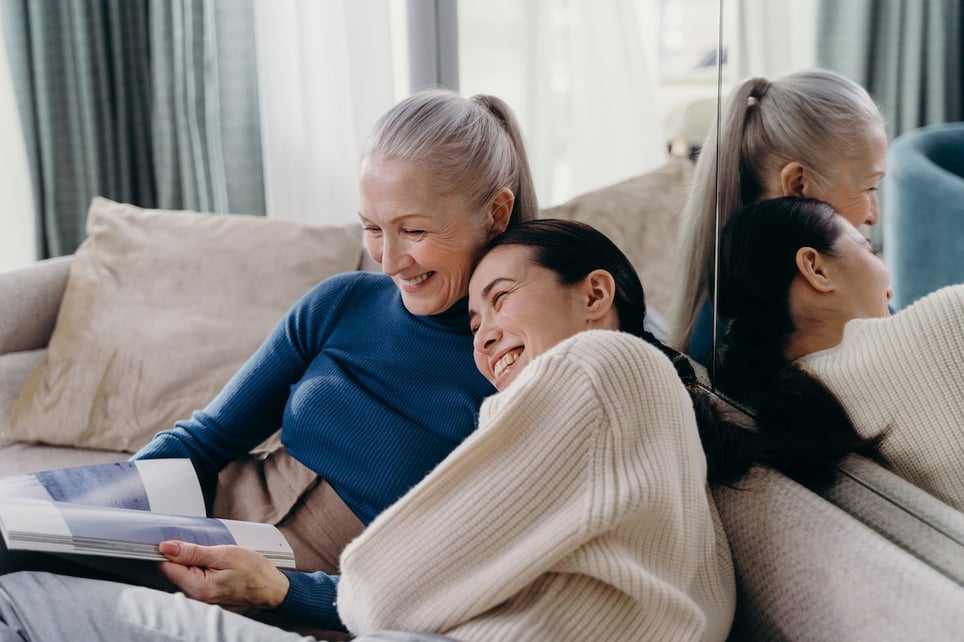Woman-with-her-mother-laughing-and-hugging-at-home-sibling-comparison