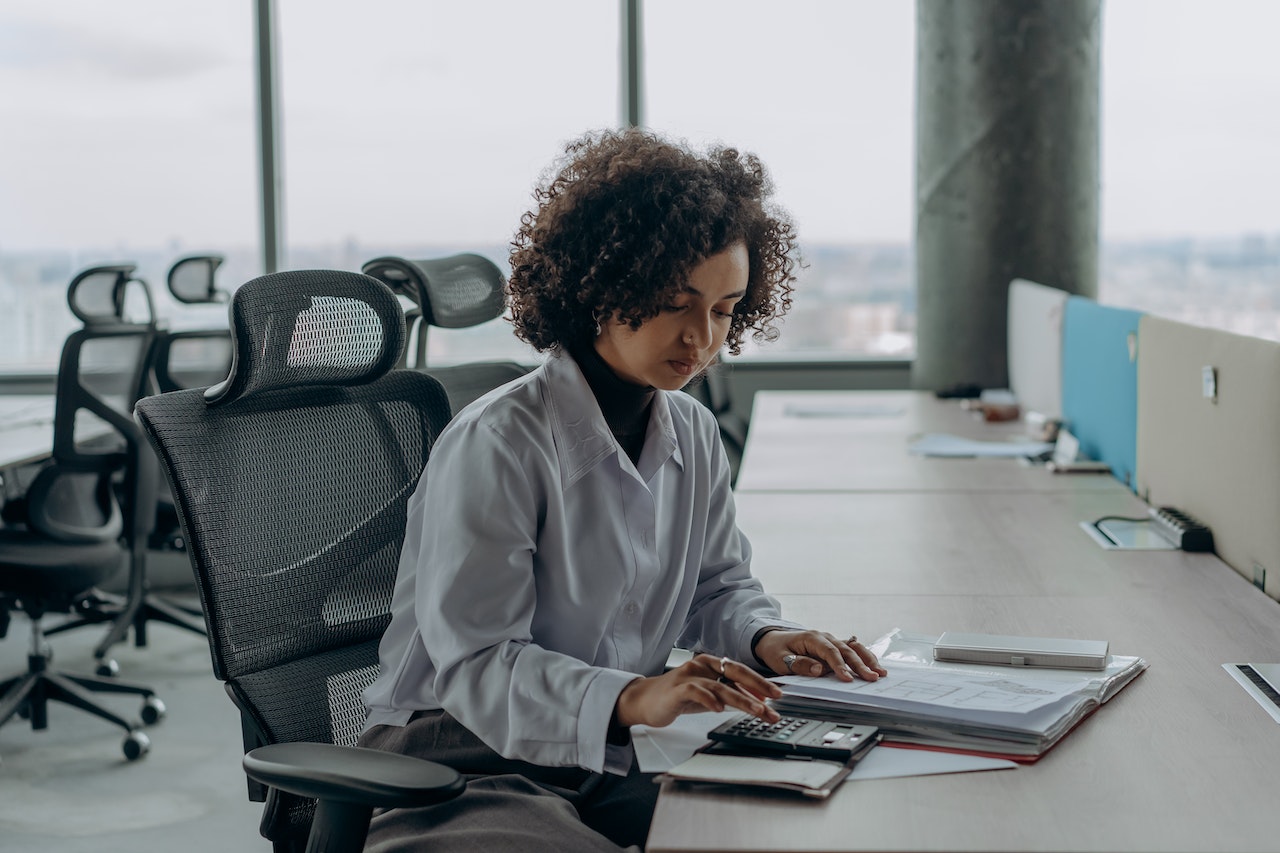 Woman-working-at-office-using-calculator-personal-branding