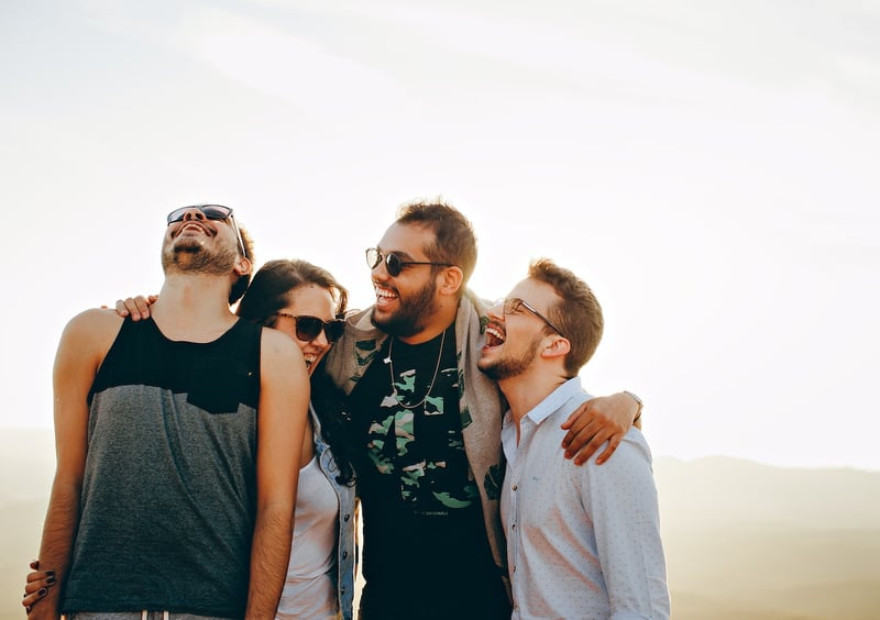 group-of-friends-laughing-together-while-hugging-and-watching-sunset-maslows-hierarchy-of-needs