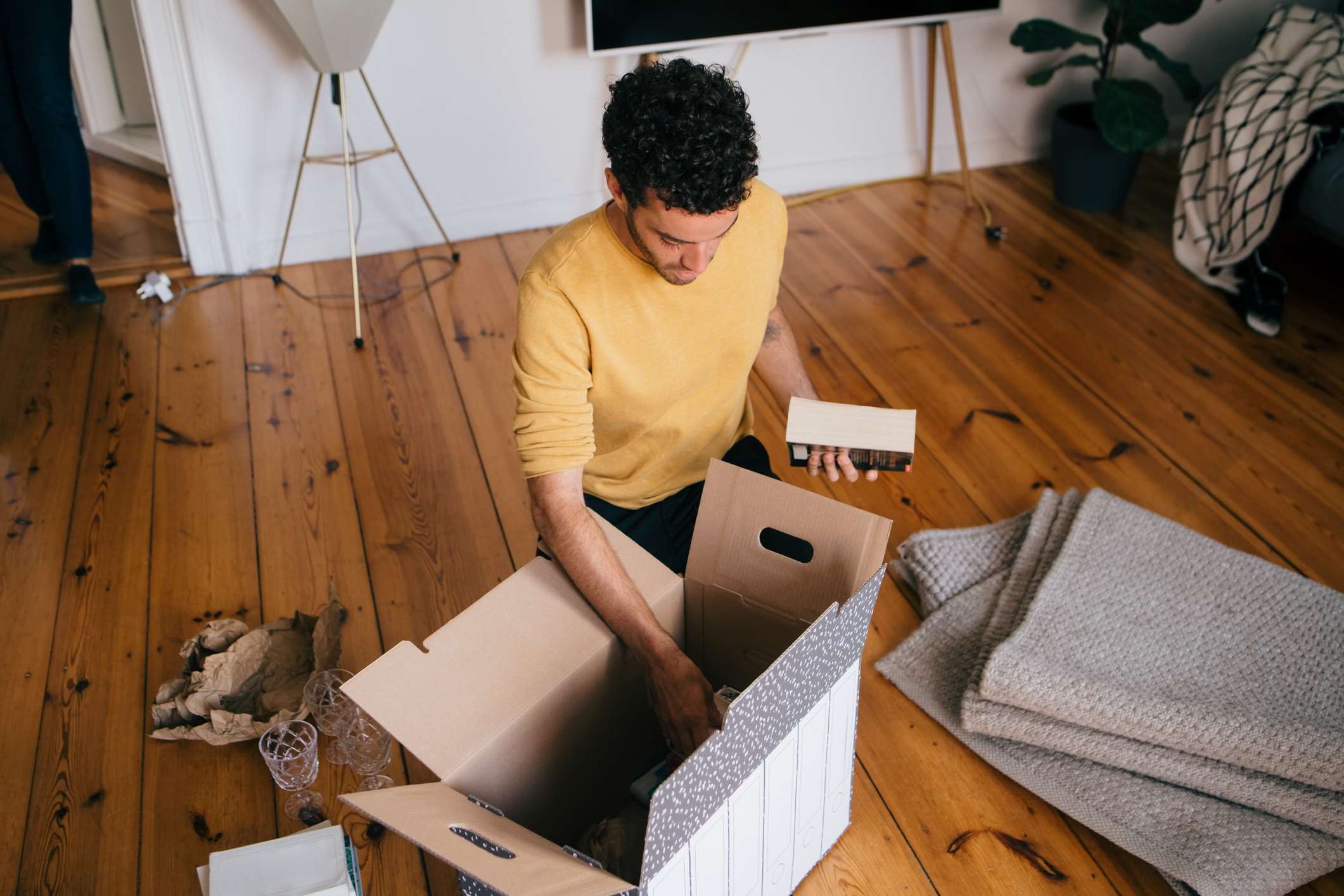 man-removing-novels-from-cardboard-box-at-new-home-why-are-you-looking-for-a-new-job