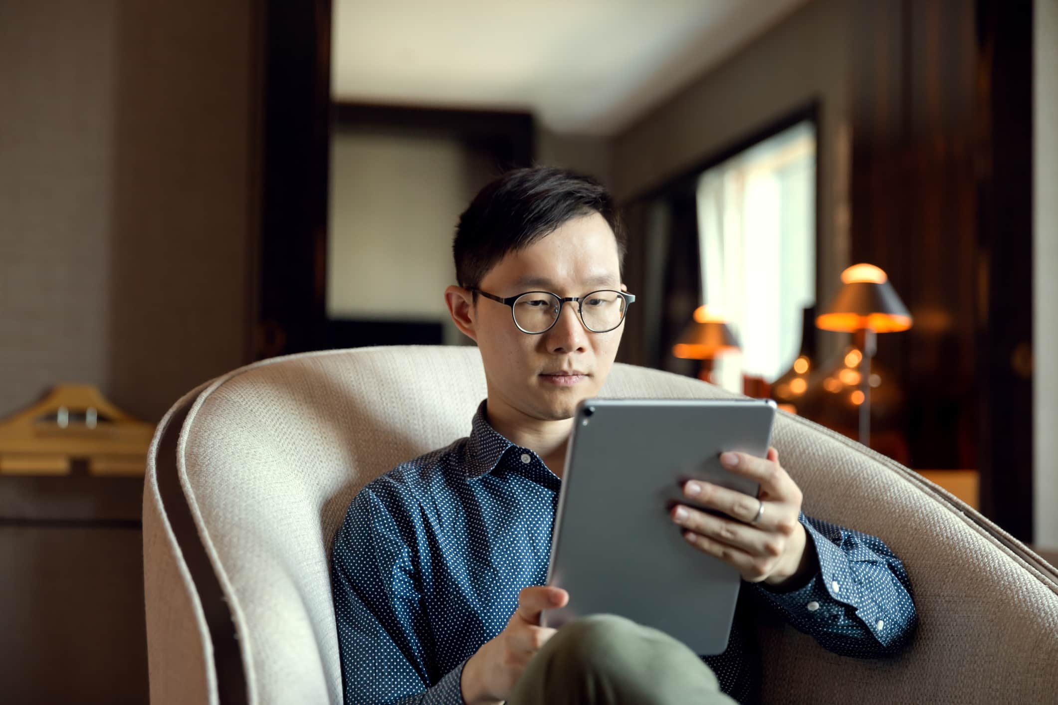 man-using-ipad-at-hotel-offer-acceptance-email