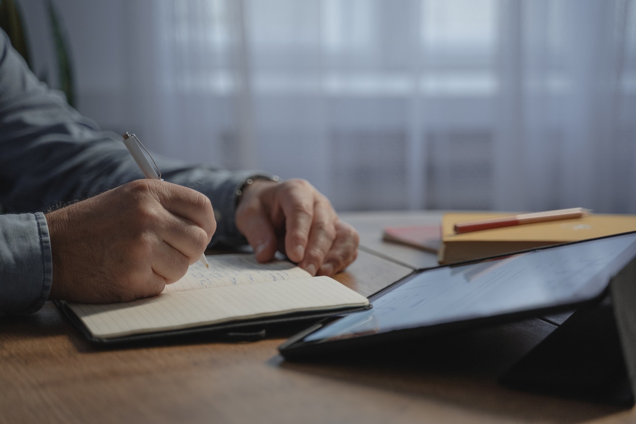 man-writing-in-notebook-priority-matrix