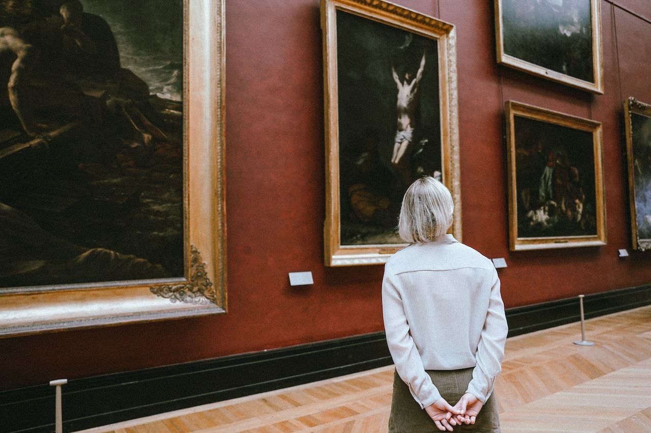 older-woman-looking-at-paintings-at-museum-maslows-hierarchy-of-needs