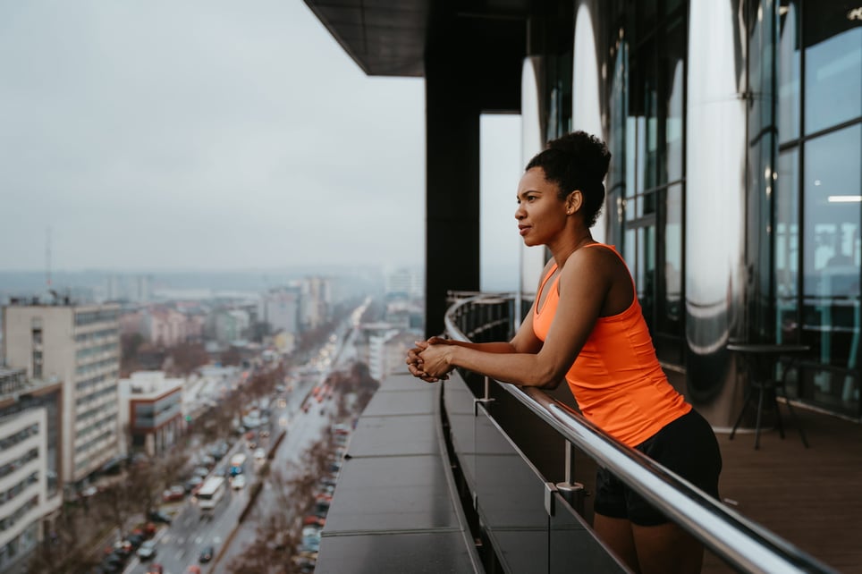 resilient-woman-looking-at-view-from-building-balcony-how-resilience-can-help-you-with-stress