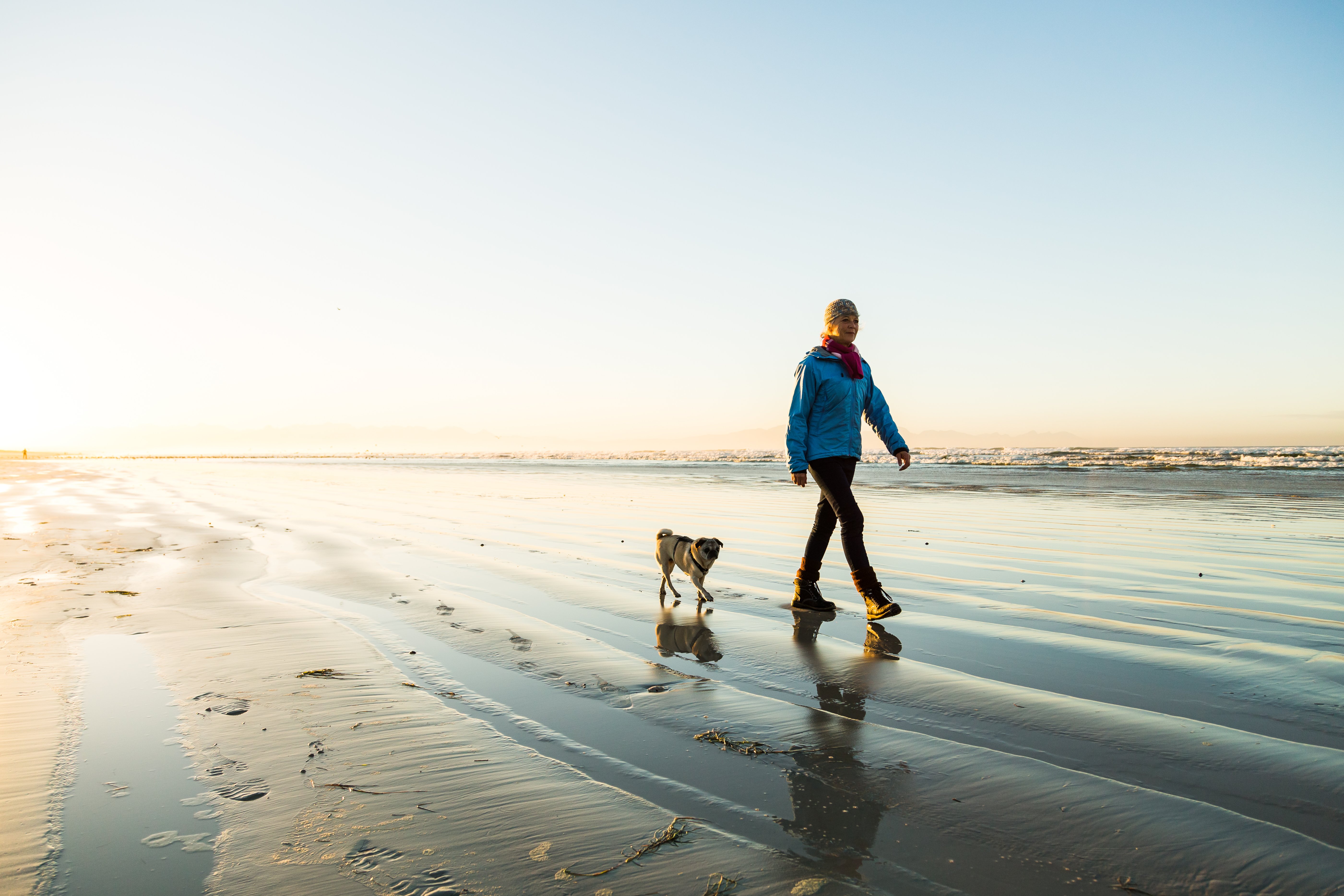 woman-walking-dog-on-beach-mental-well-being